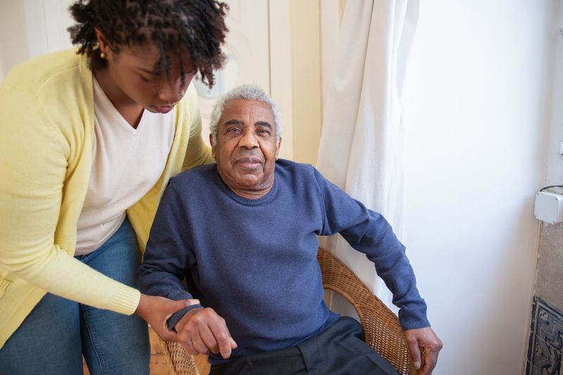 A caregiver gently assisting an elderly person